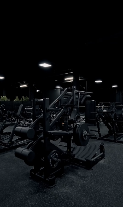 Plate-loaded strength equipment on UNIQ HQ’s black gym floor